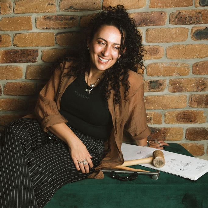 Woman sitting on a green couch with a brick wall background