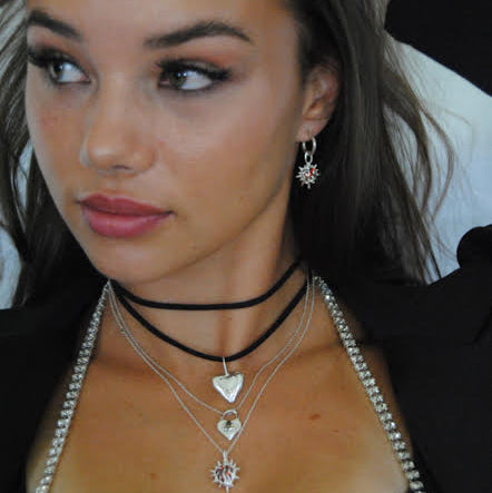 girl wearing layered necklaces and heart flame earrings