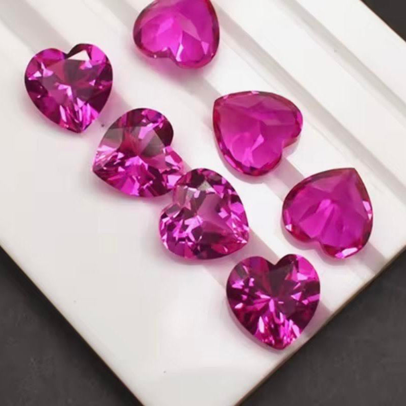 Heart-shaped pink gemstones on a white surface
