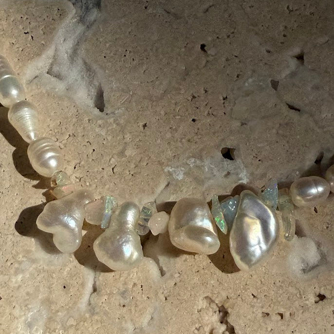 Pearl necklace on a textured beige surface