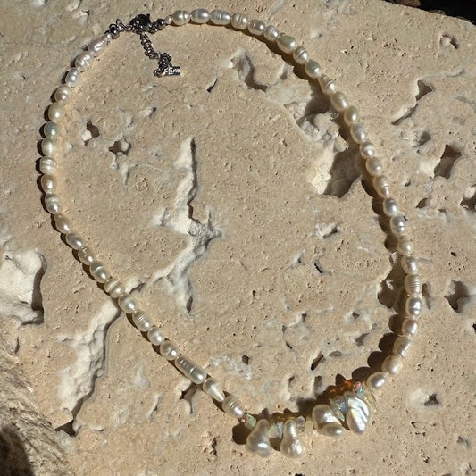 Pearl necklace on a textured stone surface